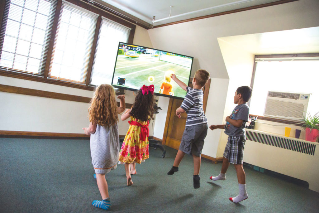 Four children play Xbox Kinect at the Early Learning Center