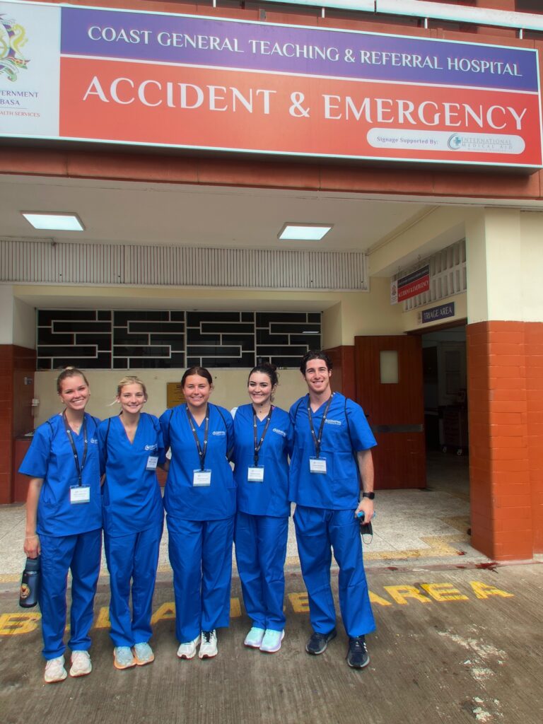 Gianna Noble poses with four other medical interns in front of a hospital